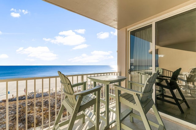 balcony featuring a water view and a beach view