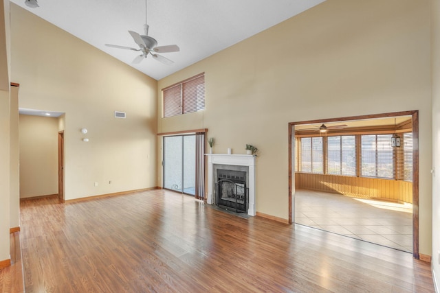 unfurnished living room with ceiling fan, light hardwood / wood-style flooring, and high vaulted ceiling