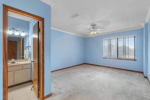 spare room with light carpet, ceiling fan, crown molding, and sink