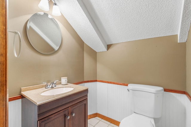 bathroom with tile patterned floors, a textured ceiling, toilet, and vanity