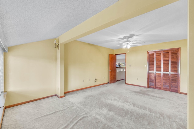 unfurnished room with ceiling fan, a textured ceiling, and carpet flooring