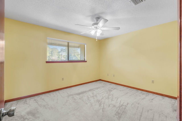 carpeted spare room with ceiling fan and a textured ceiling