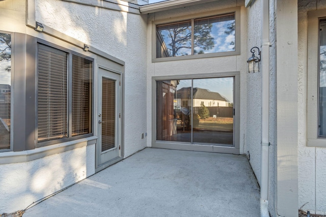 view of exterior entry featuring a patio area