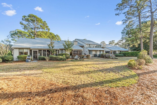 ranch-style home featuring a front yard and a sunroom