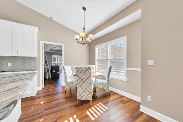 unfurnished dining area with an inviting chandelier, baseboards, vaulted ceiling, and dark wood-style flooring