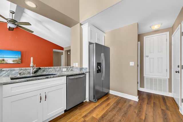 kitchen featuring light stone countertops, appliances with stainless steel finishes, white cabinets, and a sink