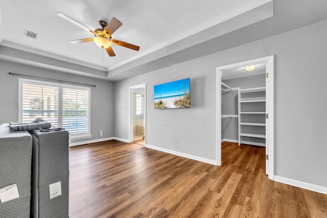 interior space featuring a raised ceiling, wood finished floors, and baseboards