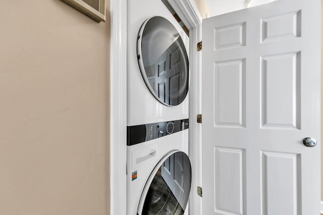 laundry room featuring stacked washer / drying machine and laundry area