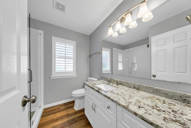 bathroom featuring a stall shower, a wealth of natural light, visible vents, and wood finished floors