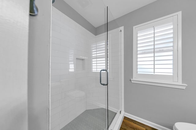 bathroom with a stall shower, visible vents, baseboards, and a wealth of natural light