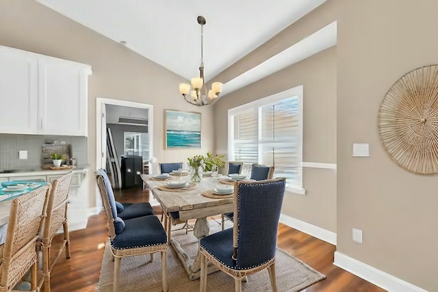 dining area featuring lofted ceiling, dark wood-type flooring, a chandelier, and a wealth of natural light