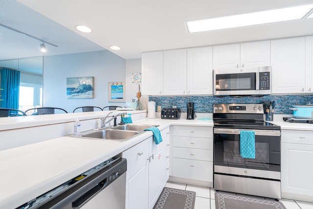 kitchen featuring decorative backsplash, white cabinetry, sink, and appliances with stainless steel finishes