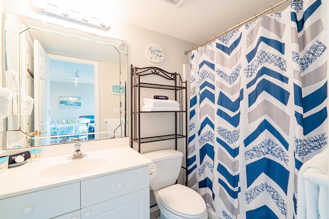 bathroom with vanity, toilet, and curtained shower