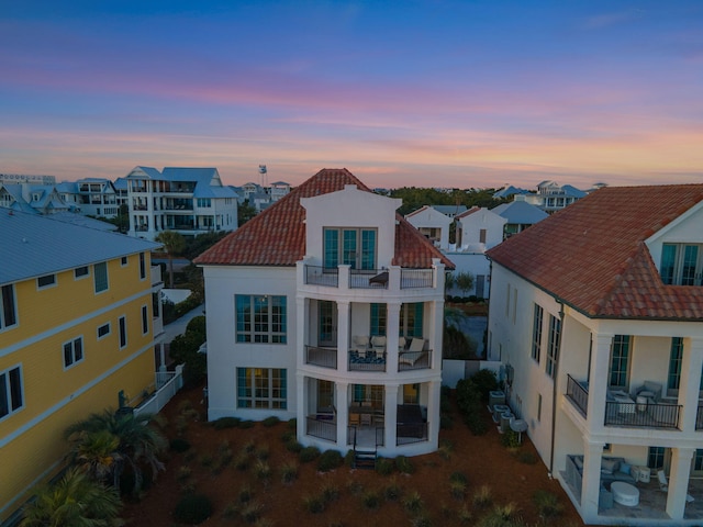 back house at dusk with a balcony