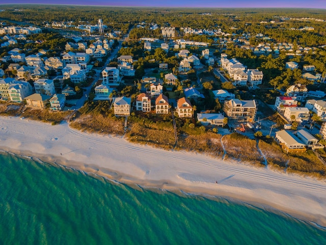 aerial view at dusk featuring a beach view and a water view