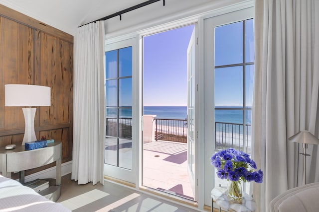 bedroom with multiple windows, light tile patterned flooring, and a water view