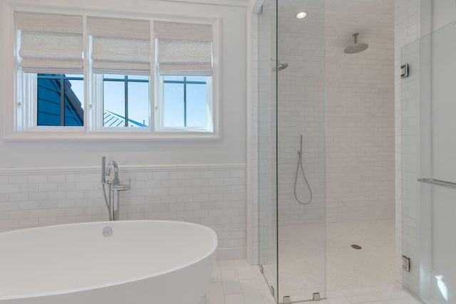 bathroom with tile patterned floors, tile walls, and plus walk in shower