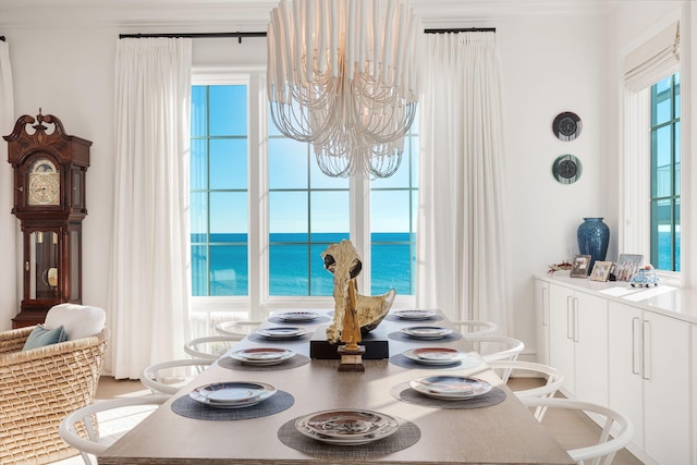 dining space with a water view and a chandelier