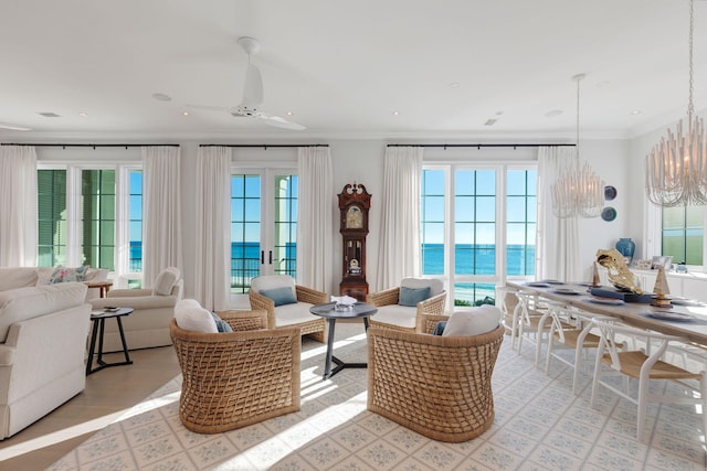 interior space featuring french doors, a water view, and ceiling fan with notable chandelier