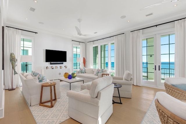 living room with ceiling fan, ornamental molding, and light hardwood / wood-style flooring