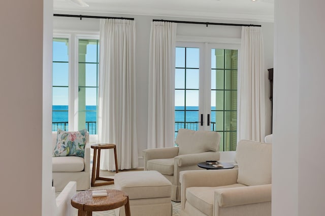 sitting room featuring ornamental molding and a water view