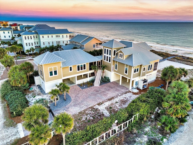 aerial view at dusk with a view of the beach and a water view