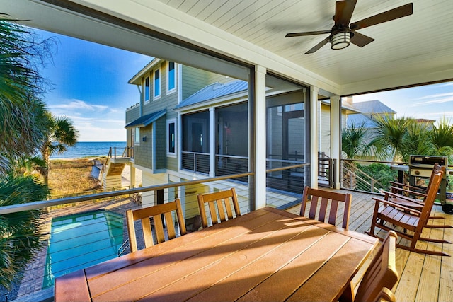 deck featuring ceiling fan, a grill, and a water view