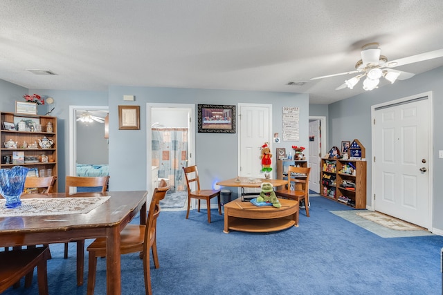 carpeted dining room featuring a textured ceiling and ceiling fan