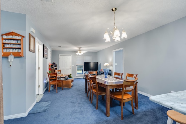 dining area featuring ceiling fan with notable chandelier, dark carpet, and a textured ceiling