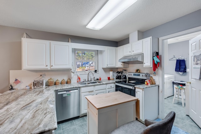 kitchen featuring stainless steel appliances, sink, white cabinetry, a textured ceiling, and a center island