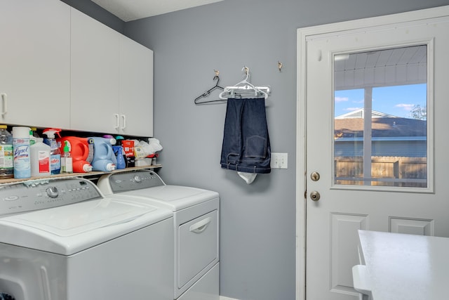 washroom featuring cabinets and washer and clothes dryer