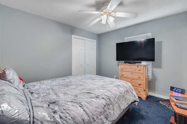 carpeted bedroom with a textured ceiling, ceiling fan, and a closet