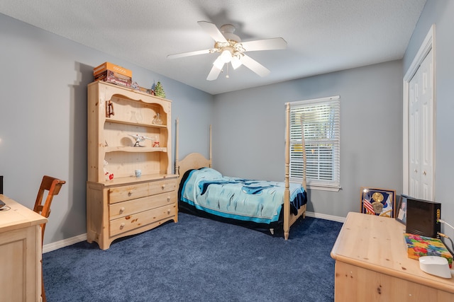 bedroom featuring a closet, ceiling fan, a textured ceiling, and dark colored carpet