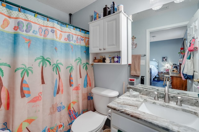 bathroom with a textured ceiling, walk in shower, vanity, and toilet