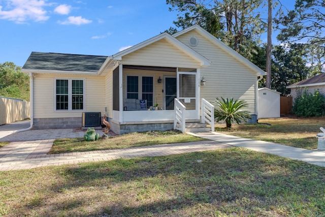 view of front facade with cooling unit, a front lawn, and a sunroom