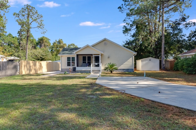 view of front of property featuring a front yard and a shed