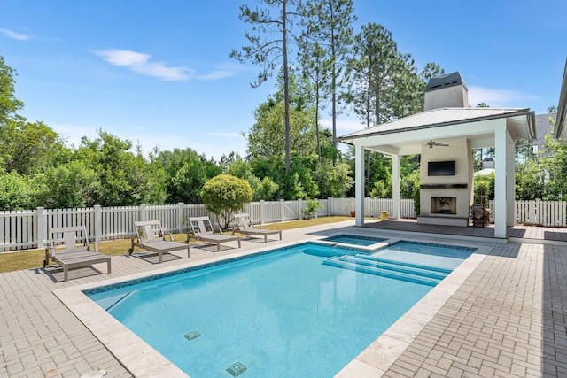 view of pool with an in ground hot tub, exterior fireplace, ceiling fan, a gazebo, and a patio