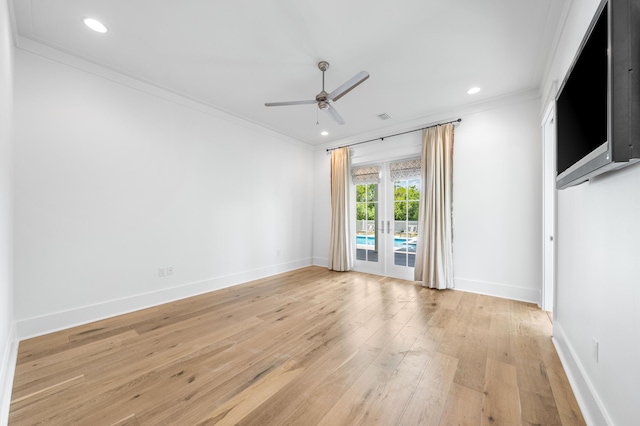 spare room with crown molding, french doors, ceiling fan, and light wood-type flooring