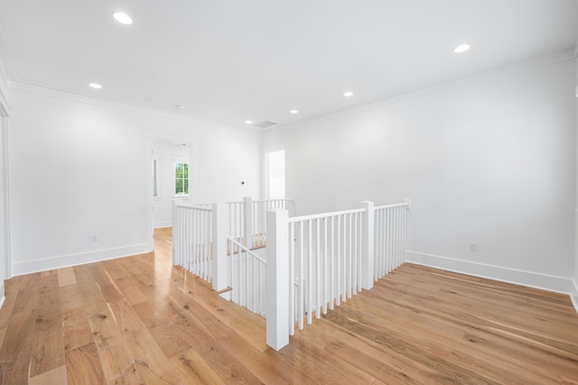 corridor featuring light wood-type flooring and crown molding