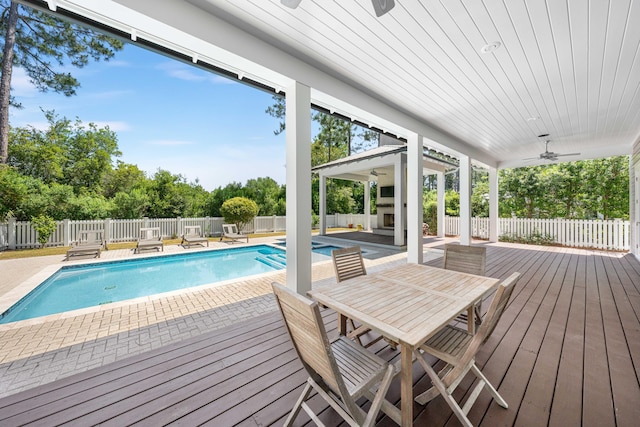 view of swimming pool featuring ceiling fan, a patio, and a deck