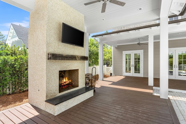 wooden deck featuring ceiling fan, french doors, and exterior fireplace