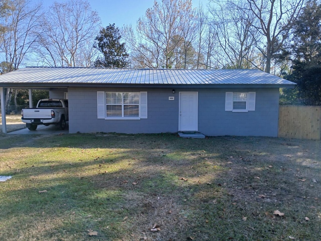 ranch-style house featuring a front yard and a carport