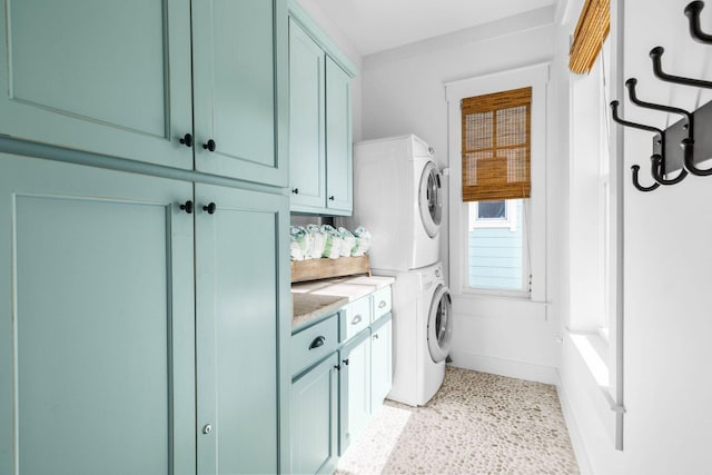 washroom with cabinets and stacked washer and clothes dryer