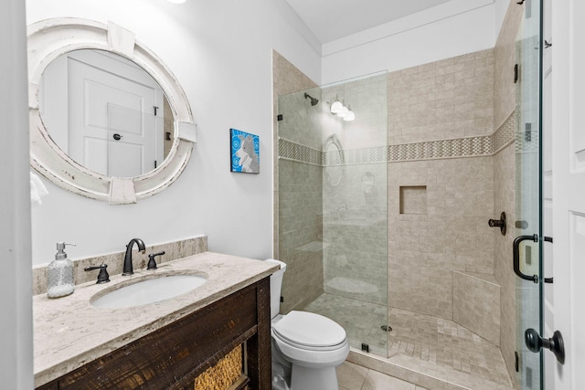 bathroom featuring tile patterned flooring, vanity, toilet, and walk in shower