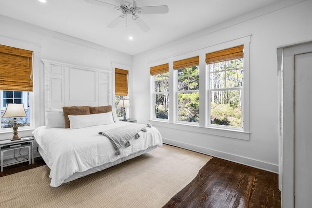 bedroom featuring multiple windows, ceiling fan, and hardwood / wood-style flooring