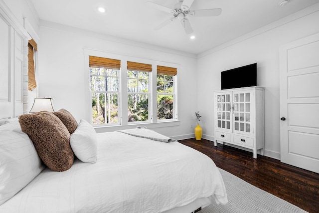 bedroom with dark hardwood / wood-style flooring, ceiling fan, and ornamental molding