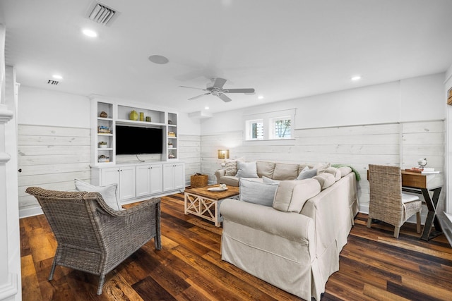 living room featuring ceiling fan, wood walls, and dark hardwood / wood-style flooring