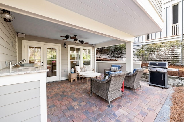 view of patio / terrace with an outdoor living space, ceiling fan, area for grilling, and a wet bar