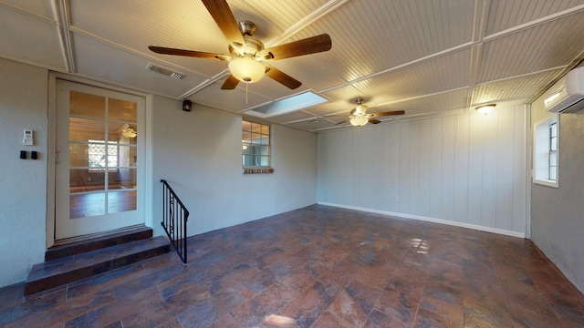 spare room featuring ceiling fan and an AC wall unit