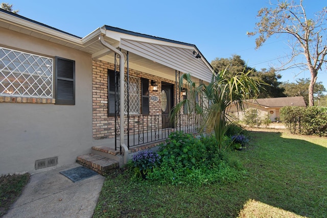 property entrance featuring a lawn